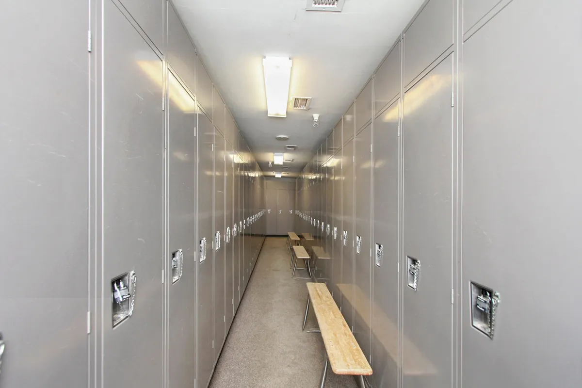 An interior shot of the resort’s ski and bike storage area, featuring sturdy metal lockers and wooden benches. The utilitarian space is well-lit and clearly organized, evoking the anticipation of gearing up for mountain adventures.